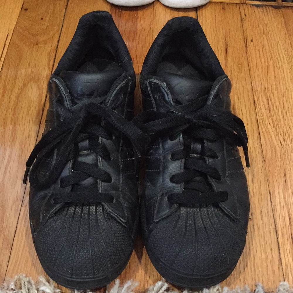 Black Adidas superstar-style sneakers